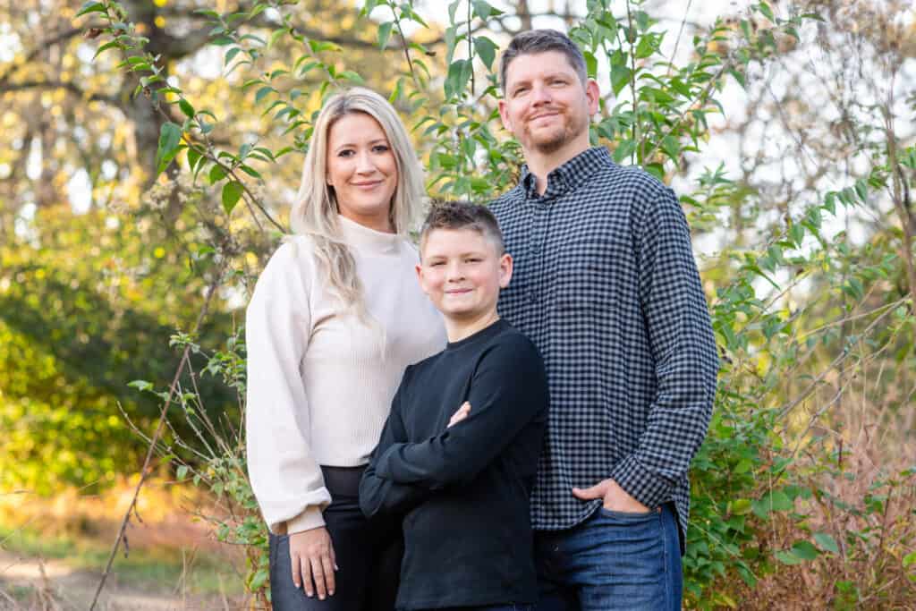 Family of three smiling at camera